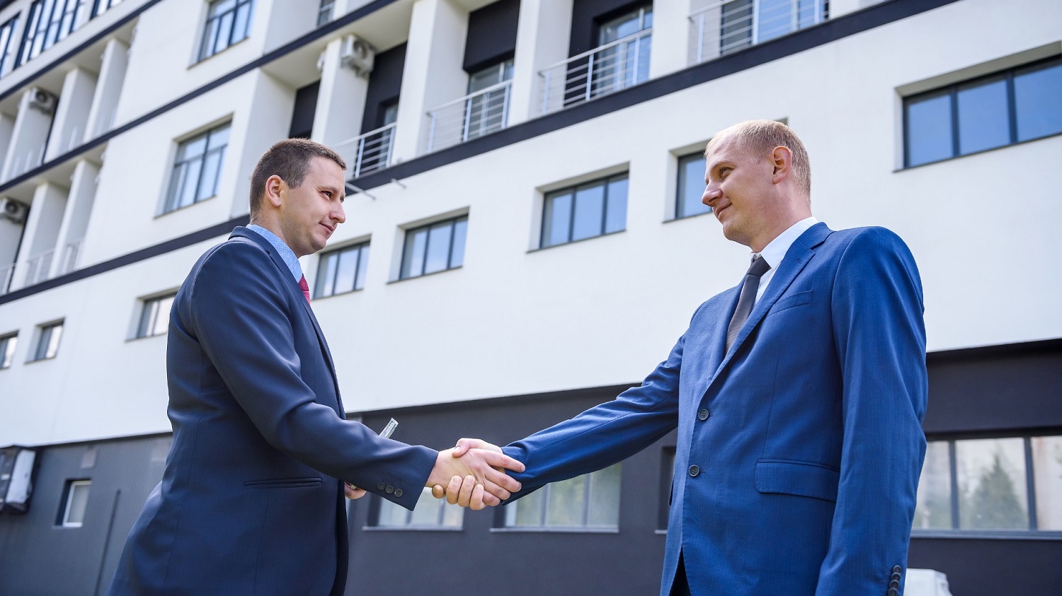 Buyers agent and property professional shaking hands after securing an investment property purchase in Australia.