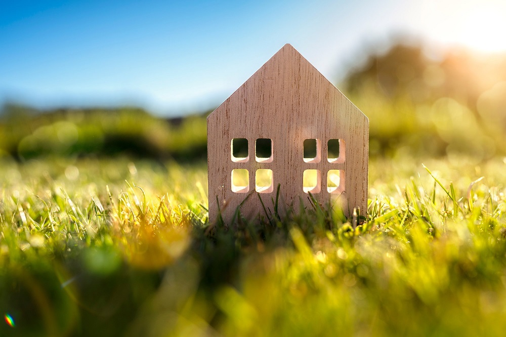 Small house model in grass symbolising family trust property investment in Australia.