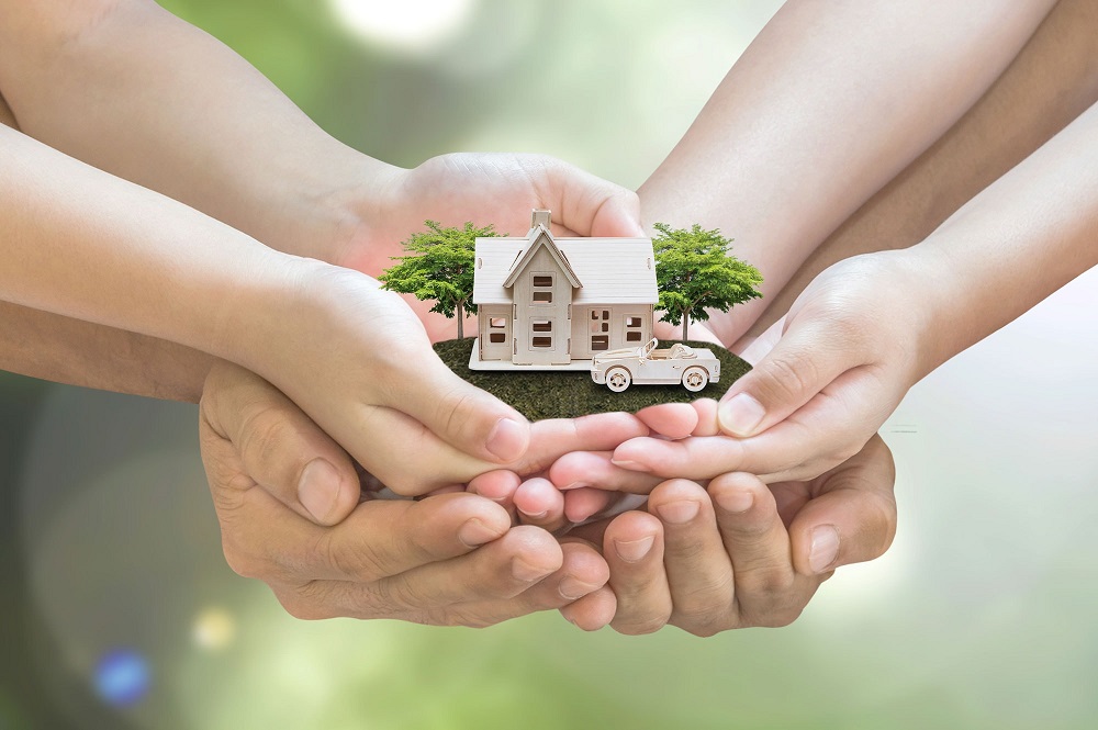 Hands holding a house model representing family trust property investment in Australia.