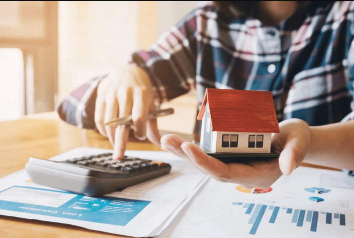 Homeowner reviewing mortgage refinance options with calculator and paperwork at home