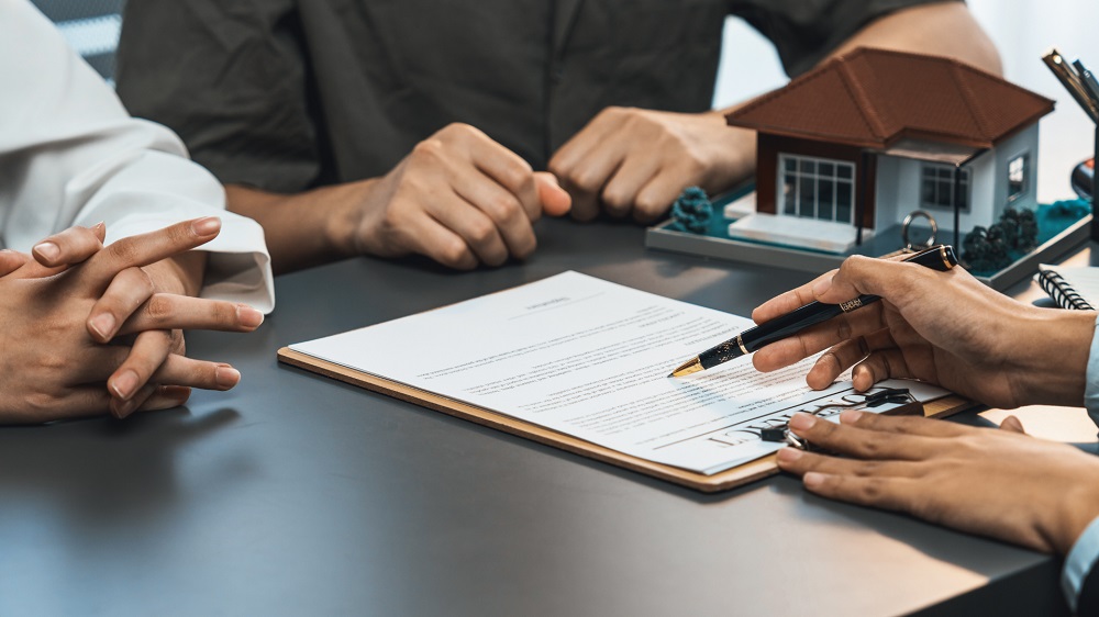 Home buyer reviewing a mortgage contract while comparing bank loans and broker options.