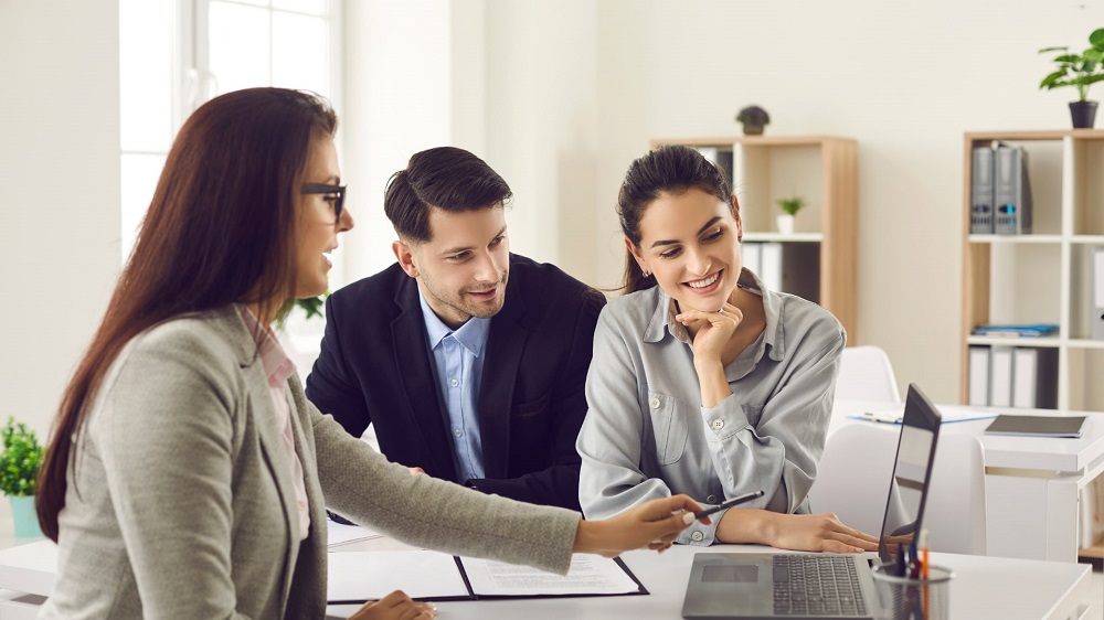Mortgage broker showing clients multiple lender options while comparing bank and broker home loan products.