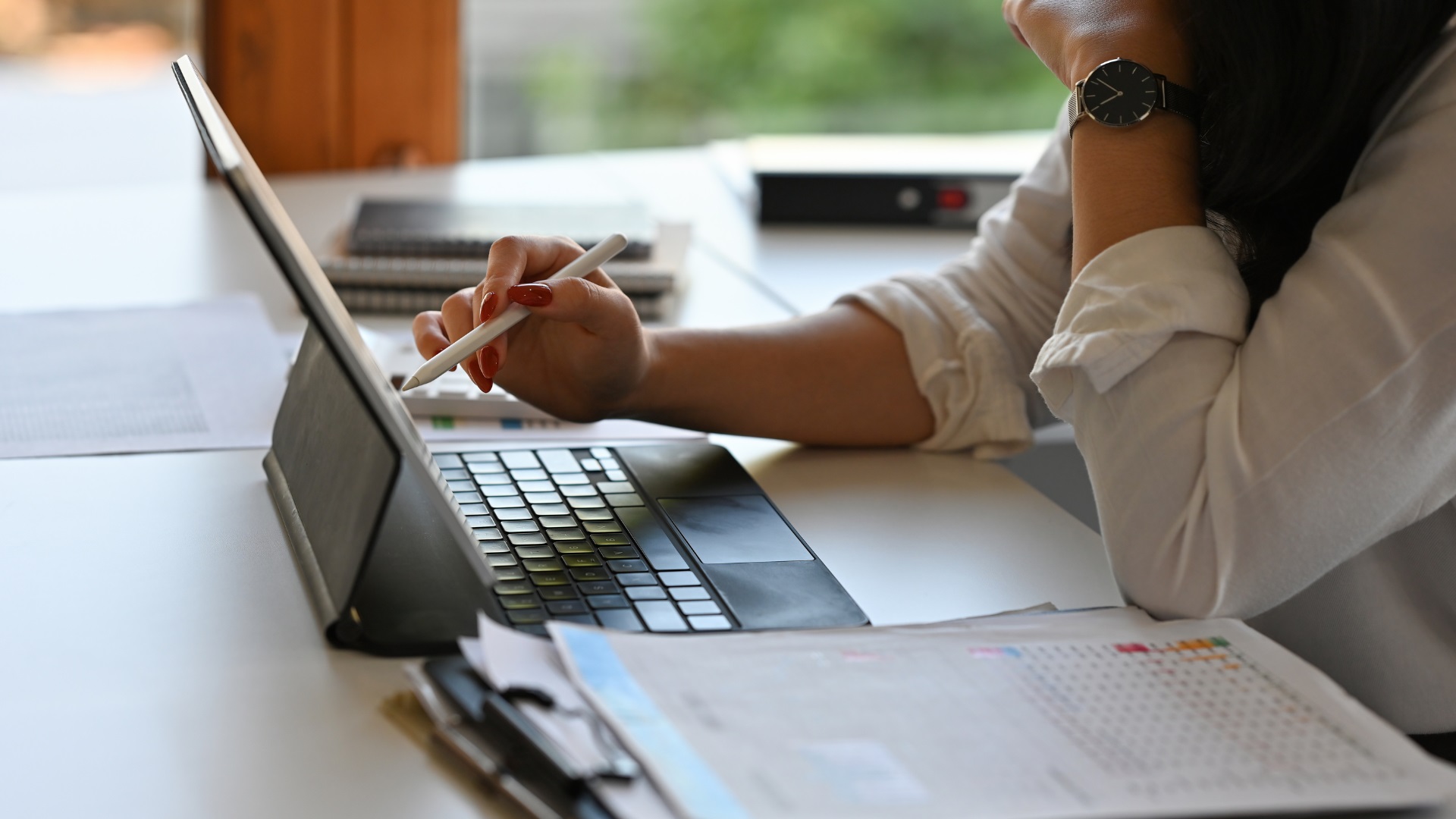 Person reviewing finances on a tablet while comparing offset account and redraw facility options for a home loan.