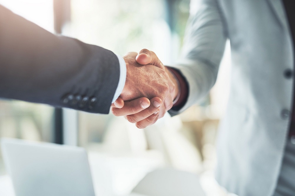 Handshake between professionals finalising a property purchase through a trust agreement in Australia.