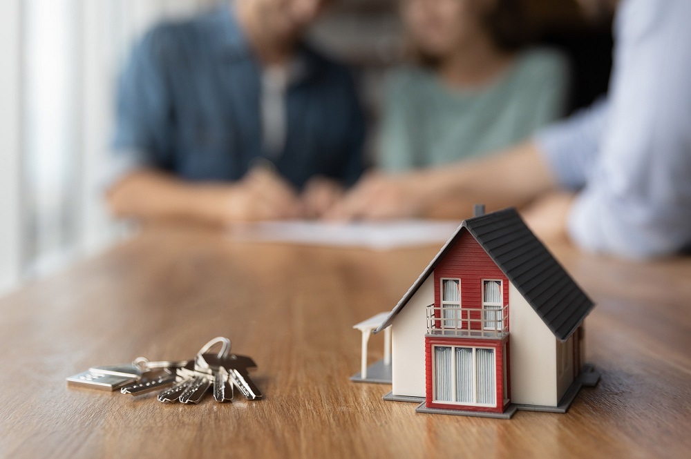 Couple signing mortgage documents with a broker when applying for a self-employed home loan in Australia.
