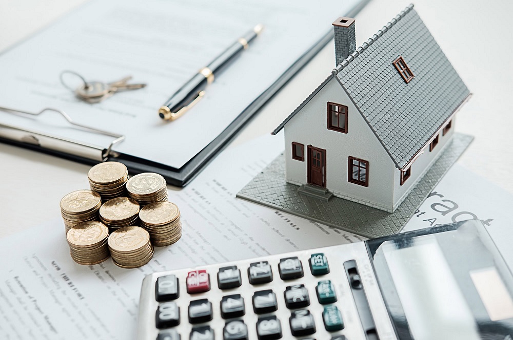 Financial calculations for a self-employed home loan in Australia with house model, coins and paperwork.