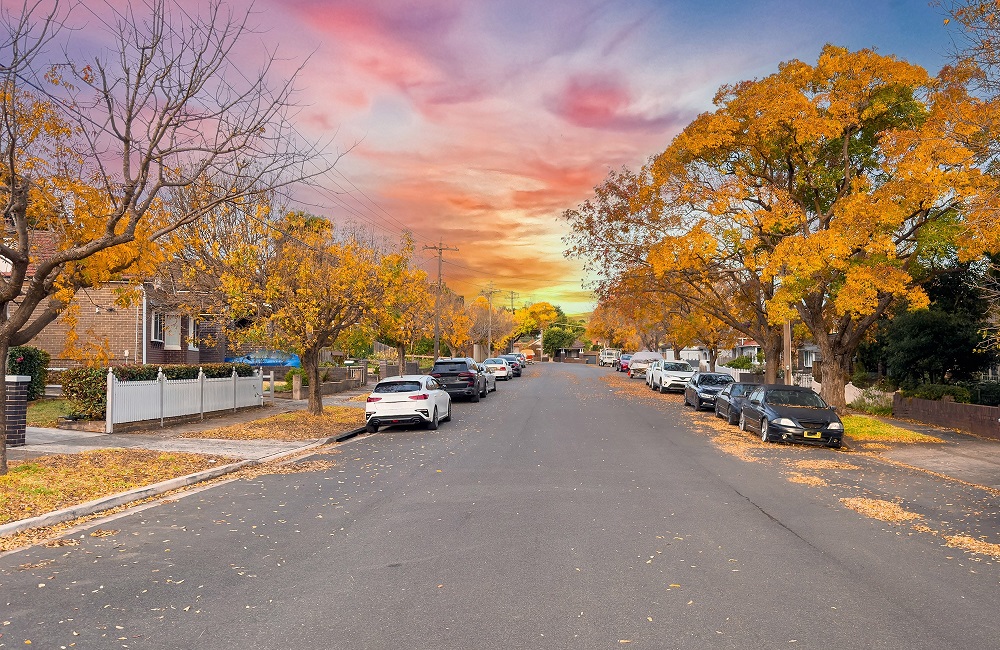 suburban street under a colorful sunset sky
